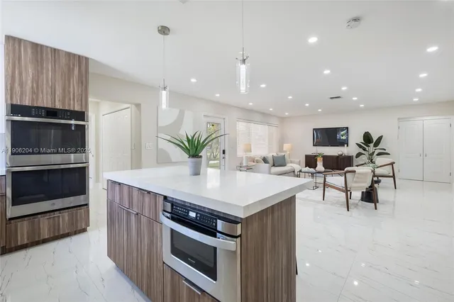 a kitchen with kitchen island white cabinets and stainless steel appliances