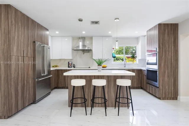 a kitchen with kitchen island granite countertop wooden cabinets and stainless steel appliances