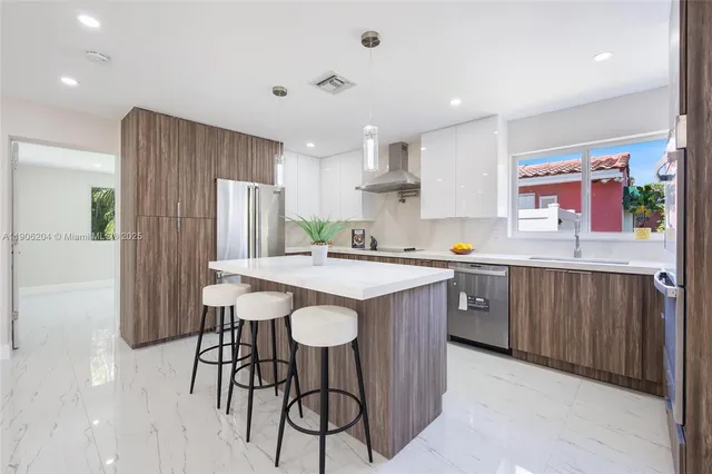 a kitchen with a table chairs refrigerator and microwave