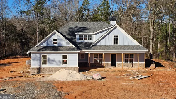 a front view of a house with a yard covered with snow