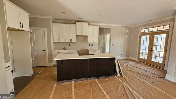 a living room with stainless steel appliances kitchen island granite countertop a refrigerator and cabinets