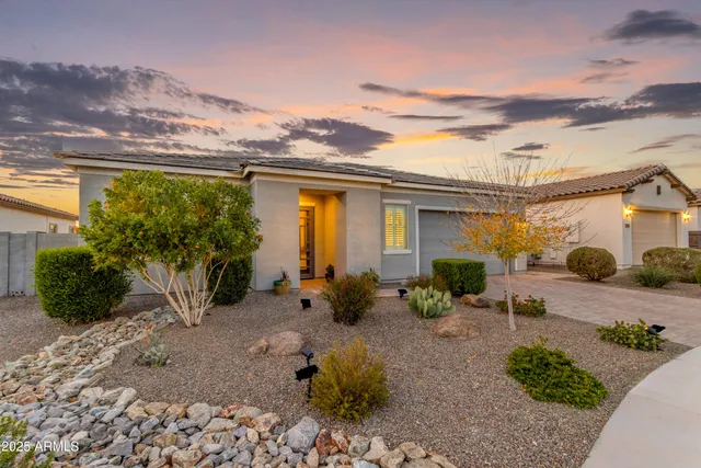 a kitchen with granite countertop a refrigerator a stove a sink a dining table and chairs