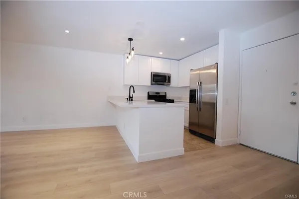 a kitchen with stainless steel appliances a refrigerator sink and microwave