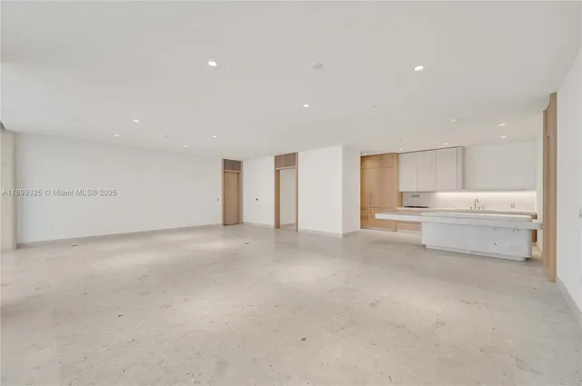 a view of a big room with white cabinet and windows