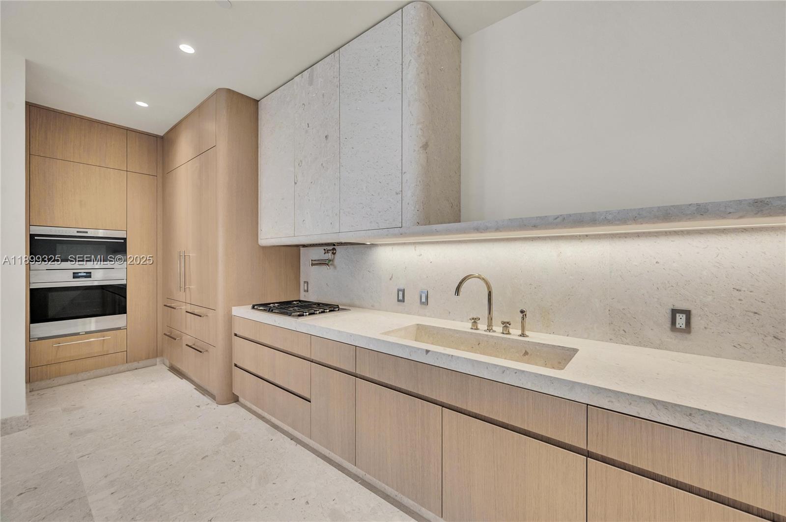 9149 Collins Avenue, Unit 602 Surfside, FL 33154 - Photo 6 of 8 a kitchen with a sink cabinets and stainless steel appliances
