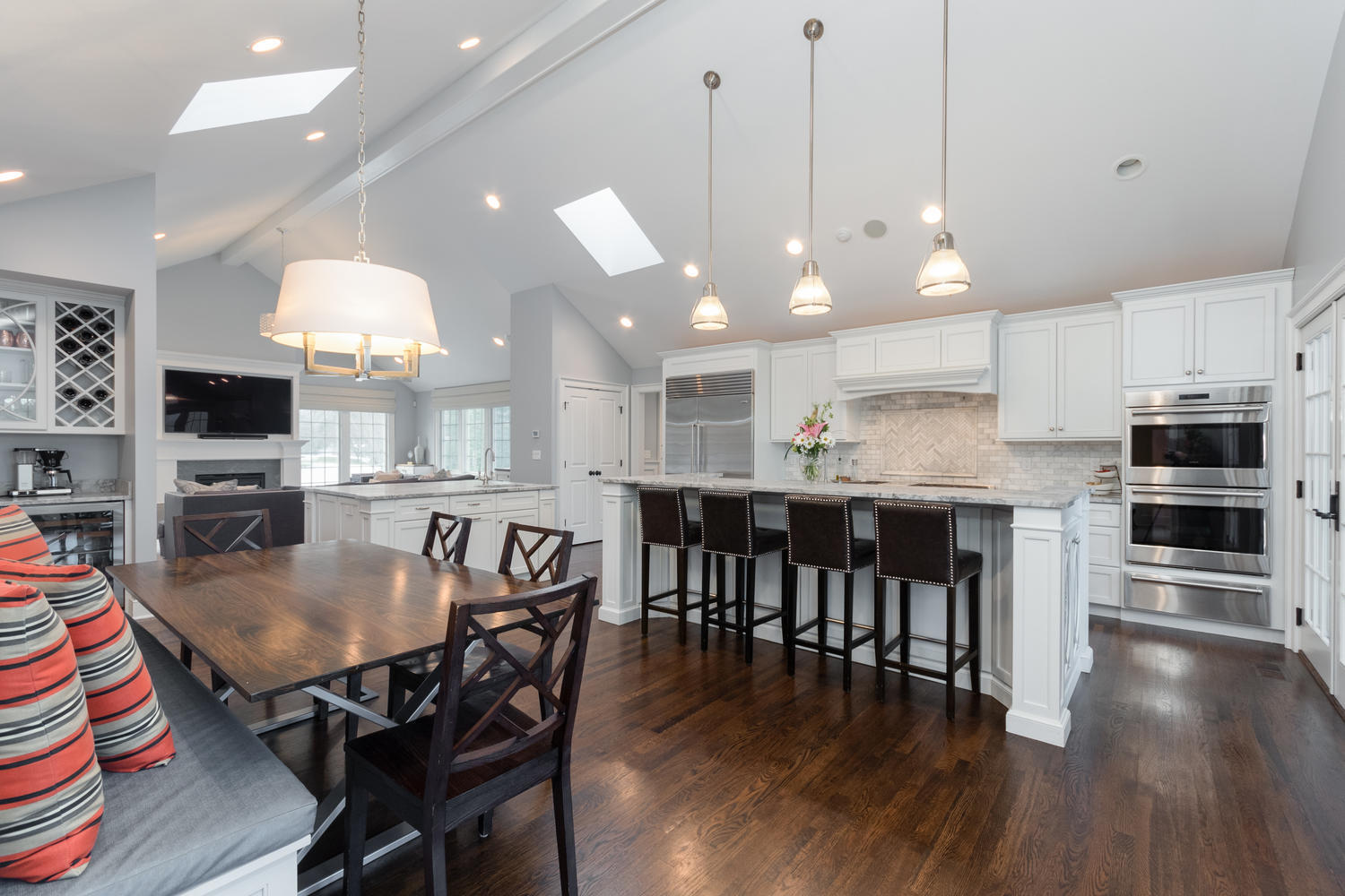 14 Deerfield Road Darien, CT 06820 - Photo 16 of 55 a kitchen with stainless steel appliances granite countertop a stove a refrigerator a kitchen island a dining table and chairs with wooden floor