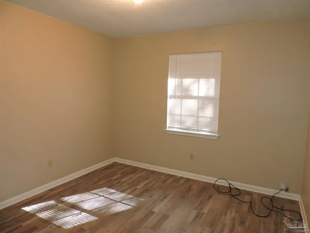 a view of a small space with wooden floor and a window
