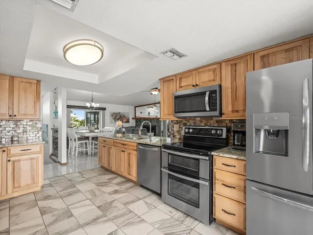 a living room with furniture a fireplace and a chandelier