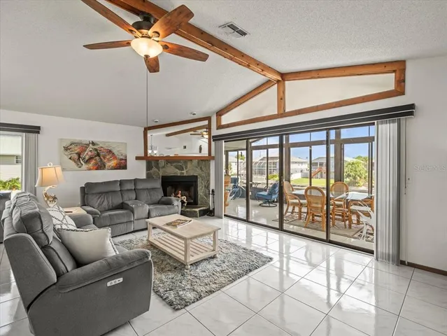 a living room with furniture ceiling fan and a large window
