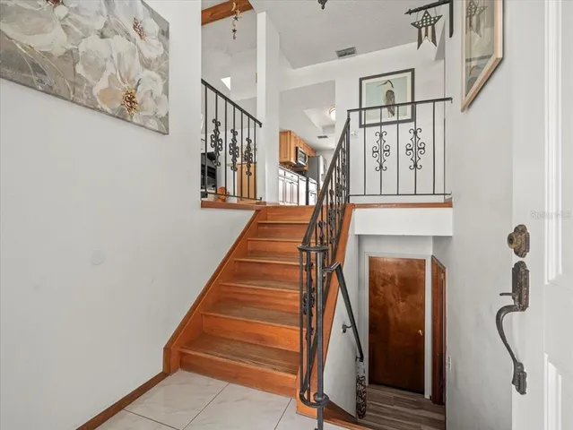 a view of a dining room with furniture a chandelier and large windows