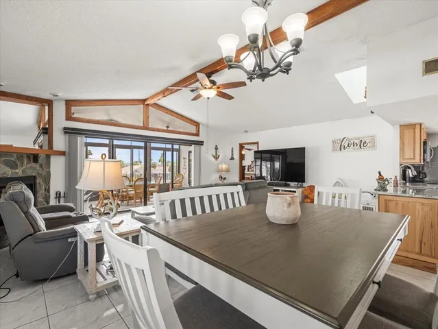 a dining hall with stainless steel appliances kitchen island granite countertop a sink and cabinets