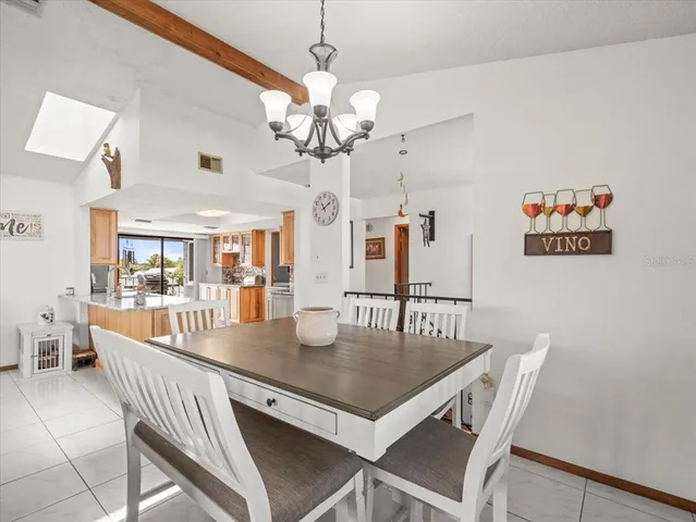 a kitchen with stainless steel appliances granite countertop a stove top oven a sink dishwasher a dining table and chairs with wooden floor