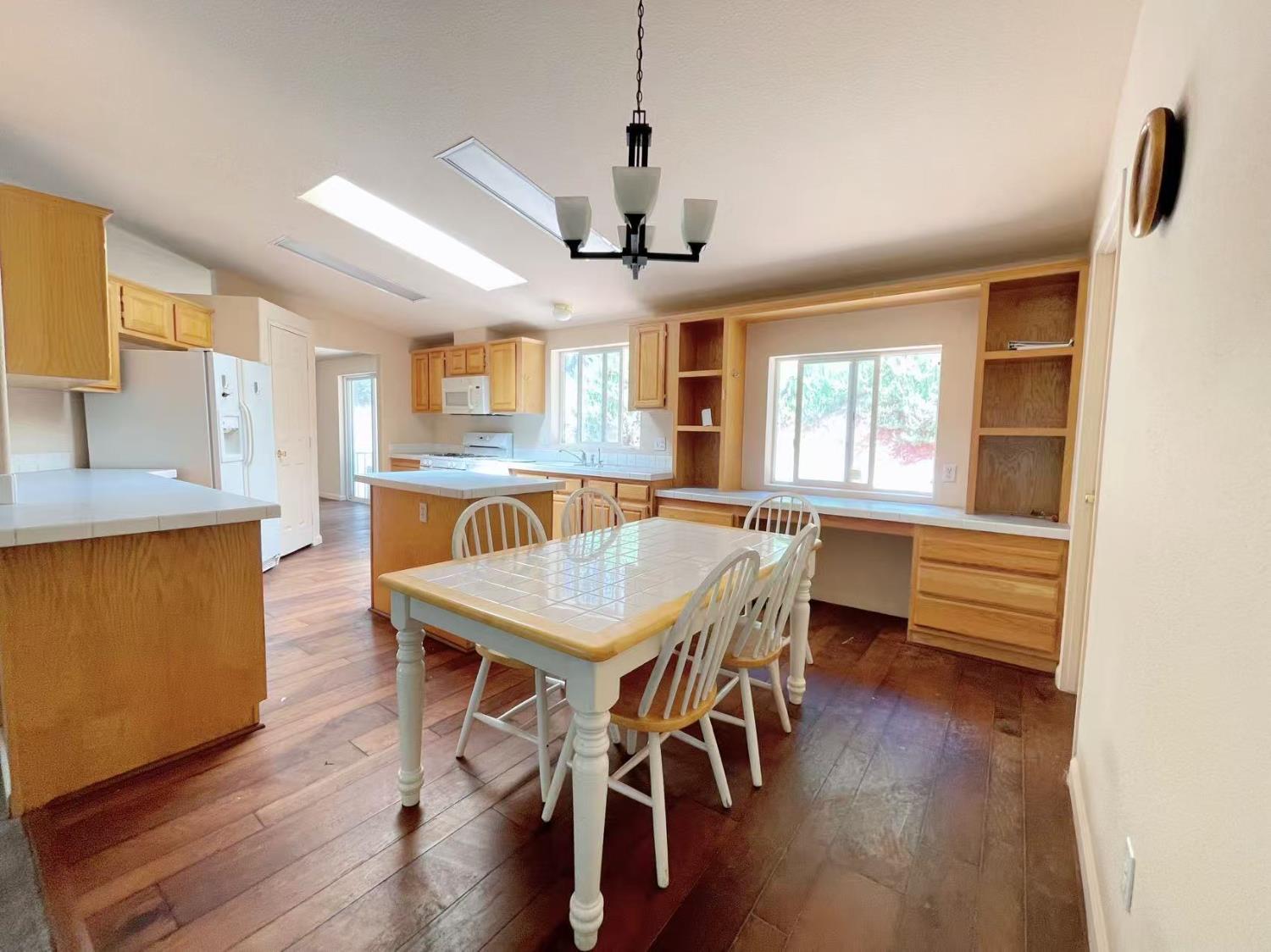 112 Renegade Road Oroville, CA 95966 - Photo 11 of 38 a dining room with wooden floor a chandelier a wooden table and chairs
