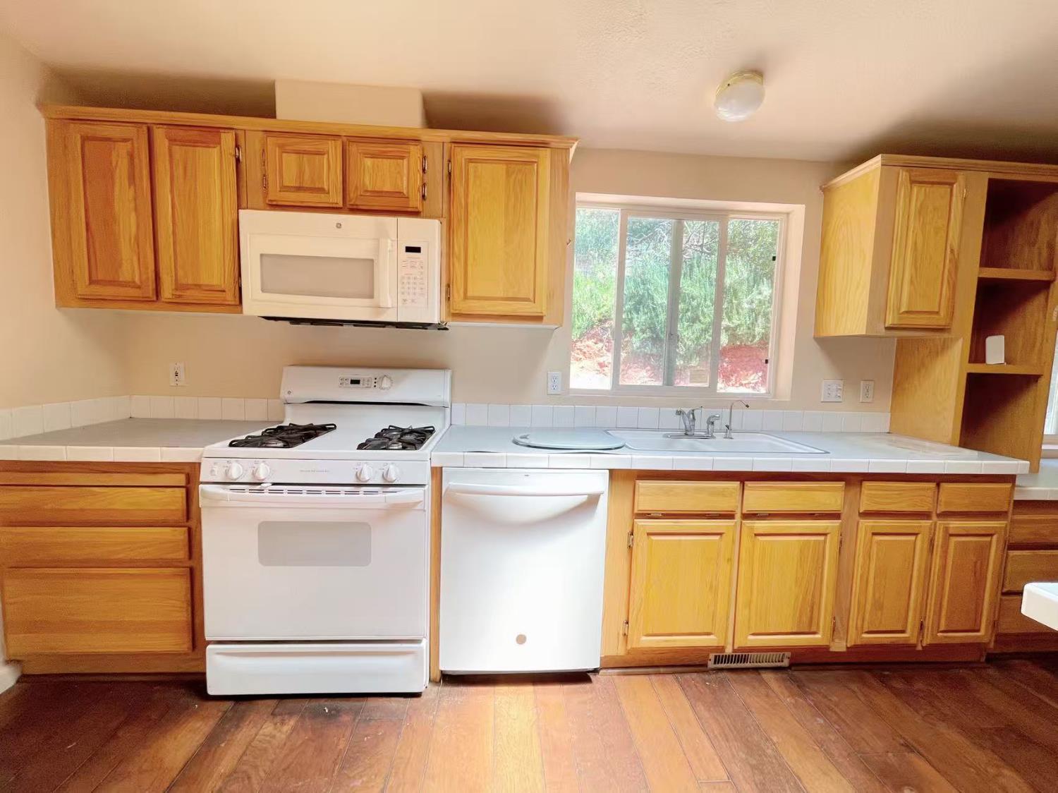 112 Renegade Road Oroville, CA 95966 - Photo 12 of 38 a kitchen with a stove a sink wooden floor and a window