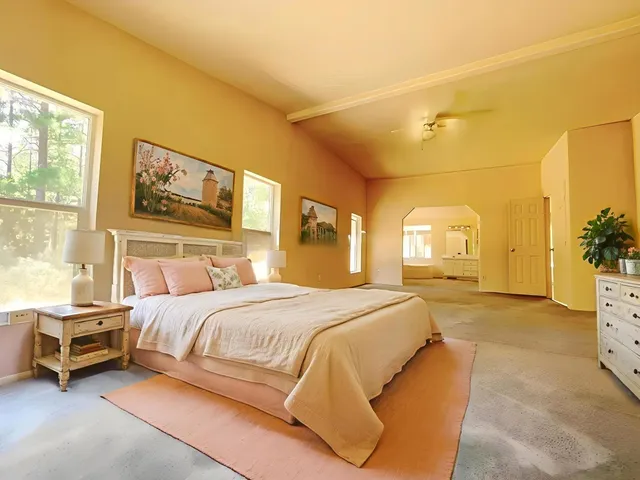 a view of an empty room with window and cabinet area