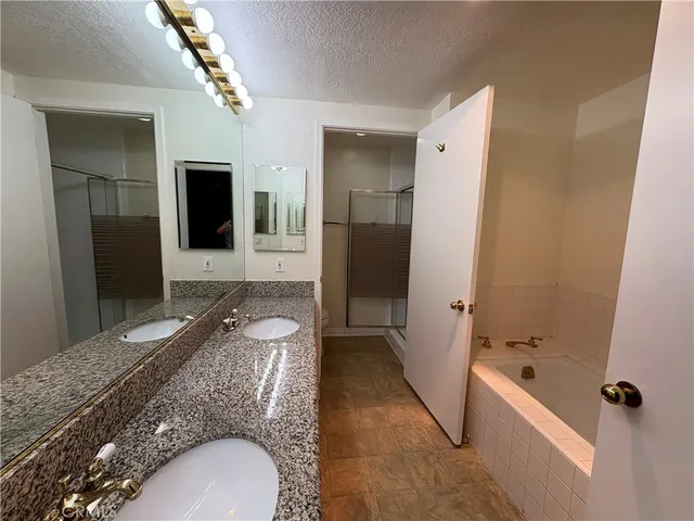 a spacious bathroom with a granite countertop tub sink and mirror