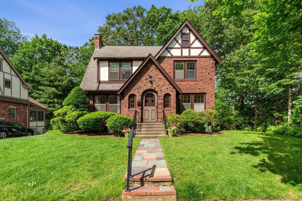 a front view of a house with a yard and potted plants