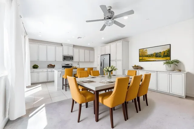 a view of a dining room with furniture and a chandelier fan