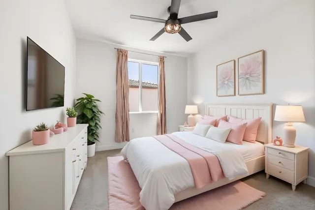 a bedroom with a bed and a flat tv screen on dresser