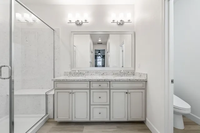 a bedroom with a bed a flat screen tv and a mirror