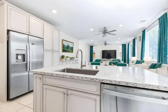 a kitchen with granite countertop a sink and refrigerator