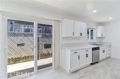 a kitchen with granite countertop white cabinets and white appliances
