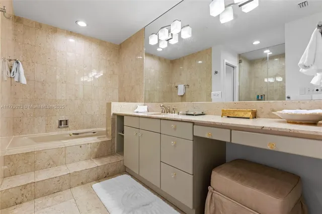 a bathroom with a granite countertop sink a toilet a mirror and bathtub