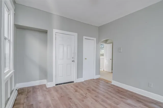 a view of an empty room with closet and a window