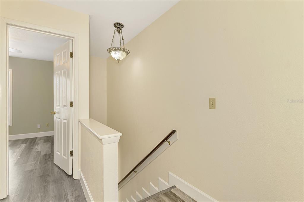 26310 Rampart Boulevard, Unit 505/E Punta Gorda, FL 33983 - Photo 20 of 64 a view of a hallway with wooden floor and staircase