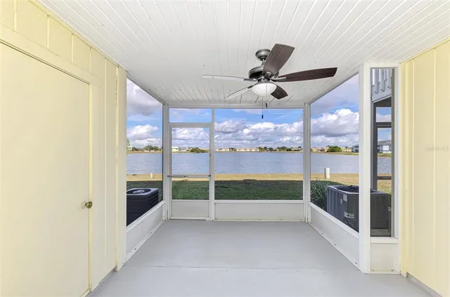a view of a backyard with lawn chairs under an umbrella