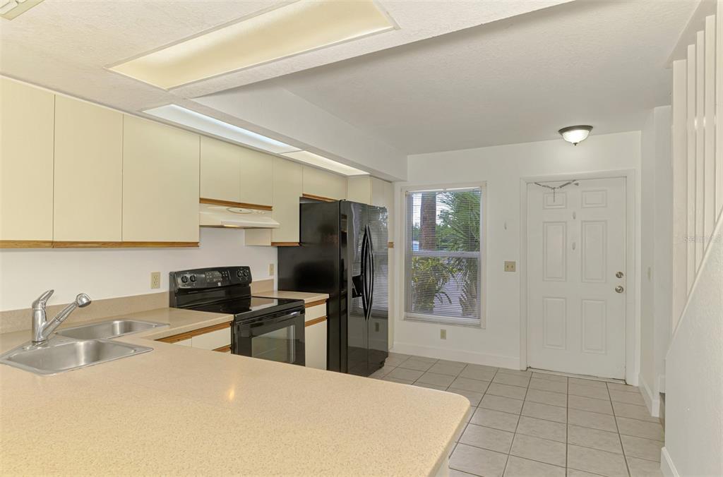 26310 Rampart Boulevard, Unit 505/E Punta Gorda, FL 33983 - Photo 8 of 64 a kitchen with a sink a refrigerator and cabinets