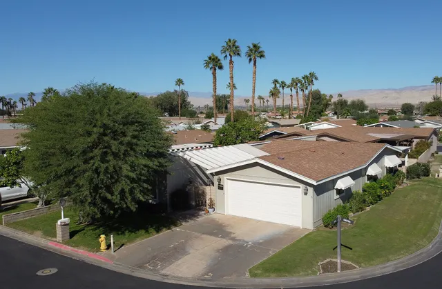 a aerial view of a house with a yard and potted plants
