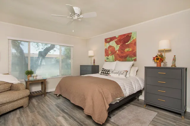 a bedroom with a large bed and a painting on the wall