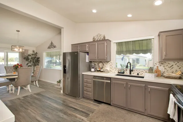 a kitchen with stainless steel appliances a sink cabinets and wooden floor