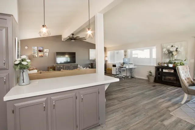a kitchen with a sink dishwasher a dining table and chairs with wooden floor