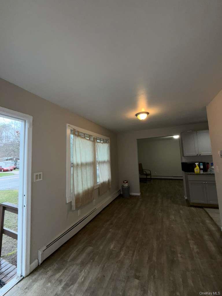 27 Panamoka Trail Ridge, NY 11961 - Photo 3 of 9 an empty room with a fireplace and windows