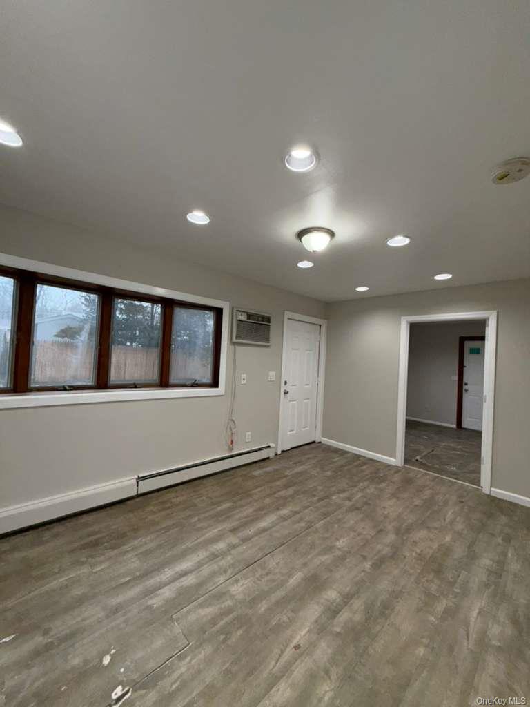 27 Panamoka Trail Ridge, NY 11961 - Photo 8 of 9 an empty room with wooden floor and windows
