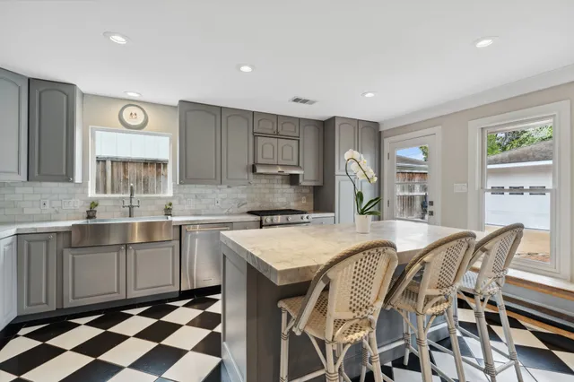 a kitchen with a table chairs sink and cabinets