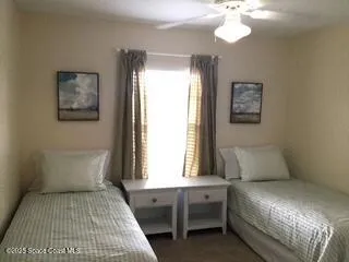 a bed sitting in a bedroom next to a window