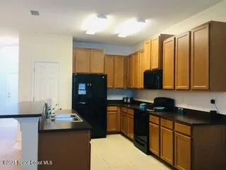 a kitchen with stainless steel appliances granite countertop a refrigerator a stove a sink dishwasher and wooden cabinets