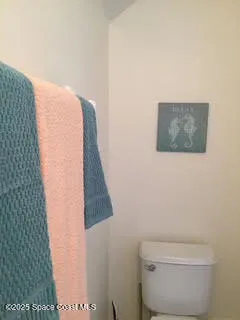 a bathroom with a toilet and a picture