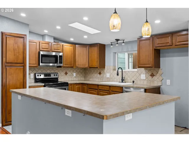 a kitchen with stainless steel appliances granite countertop a sink a stove and a microwave
