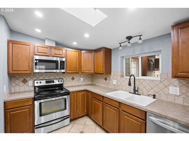 a kitchen with stainless steel appliances a stove sink and microwave