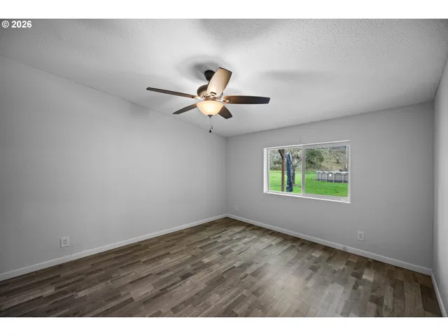 a view of room with hardwood floor and ceiling fan