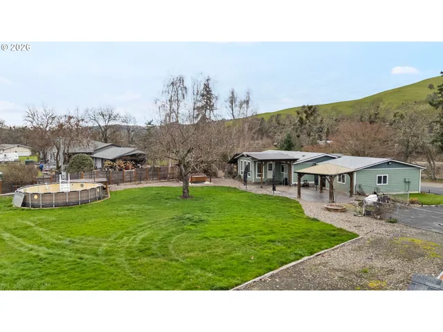 a backyard of a house with table and chairs