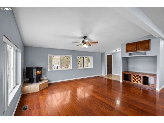 a view of empty room with a window and wooden floor