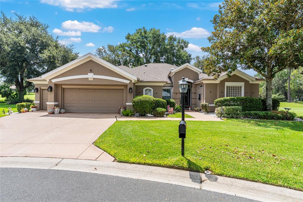 12895 Southeast 91st Terrace Road Summerfield, FL 34491 - Photo 1 of 99 a front view of a house with a garden and trees
