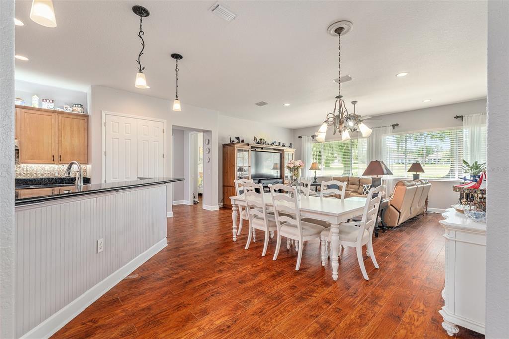 12895 Southeast 91st Terrace Road Summerfield, FL 34491 - Photo 18 of 99 a view of a dining room and livingroom with furniture wooden floor a chandelier