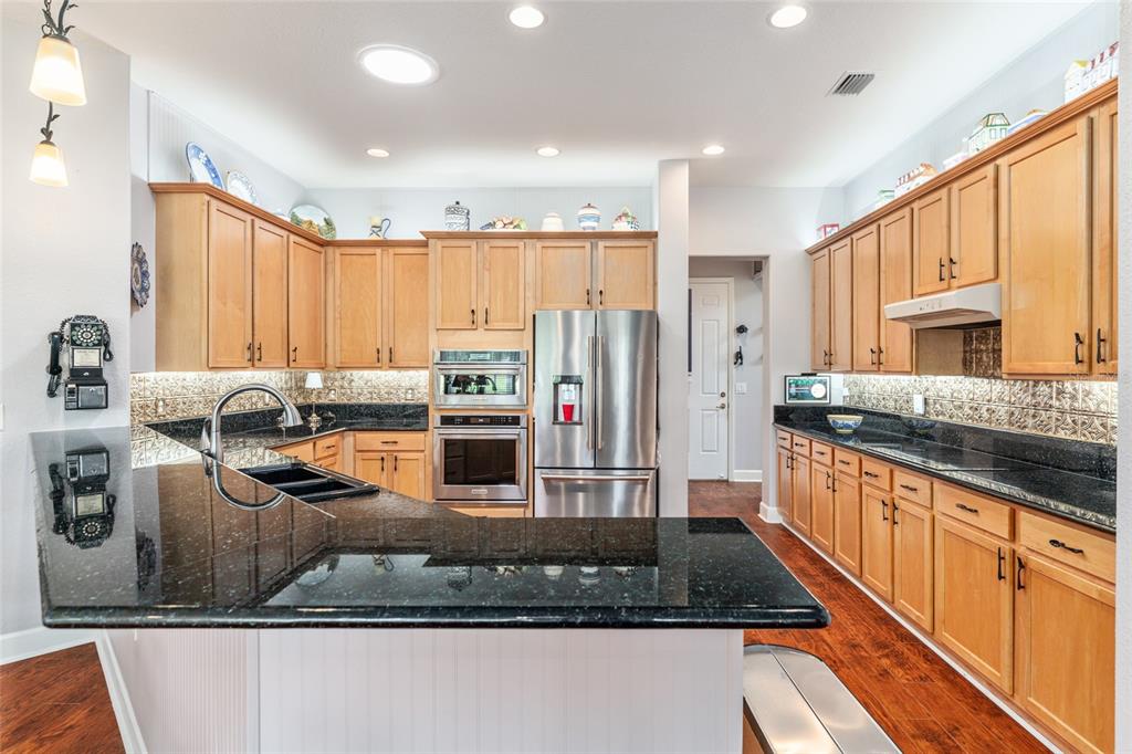 12895 Southeast 91st Terrace Road Summerfield, FL 34491 - Photo 28 of 99 a kitchen with stainless steel appliances granite countertop a stove a sink and a refrigerator