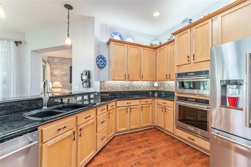 12895 Southeast 91st Terrace Road Summerfield, FL 34491 - Photo 30 of 99 a kitchen with stainless steel appliances granite countertop a stove a sink and a refrigerator